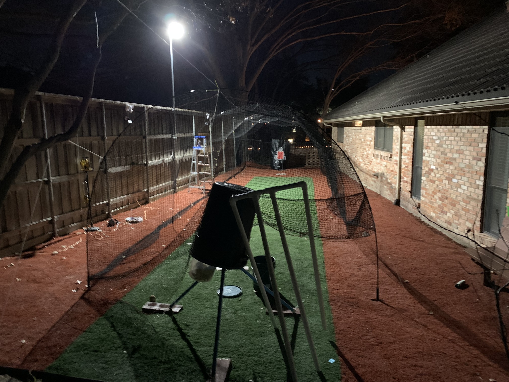 Batting cage with pitching machine and mound. Approx in Dallas, TX